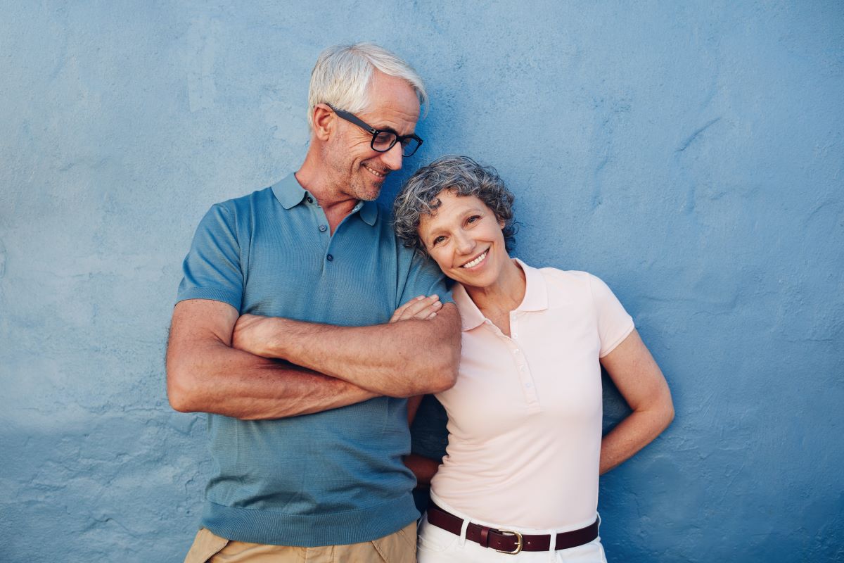 Retired couple smiling looking at a camera